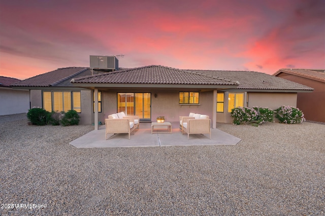 rear view of house featuring a patio, a tiled roof, outdoor lounge area, central air condition unit, and stucco siding