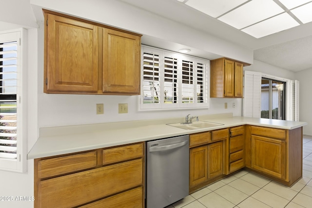 kitchen with a sink, light tile patterned flooring, a peninsula, light countertops, and dishwasher