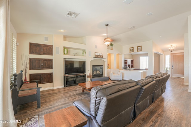 2041 E Palm Beach Dr, Chandler, AZ 85249 - living room featuring dark wood-style flooring, arched walkways, and a glass covered fireplace
