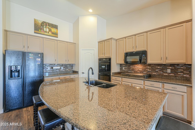 2041 E Palm Beach Dr, Chandler, AZ 85249 - kitchen featuring black appliances, a breakfast bar area, a center island with sink, decorative backsplash, and stone countertops