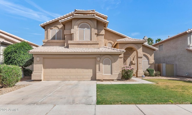 mediterranean / spanish home with a front yard, a tiled roof, an attached garage, stucco siding, and driveway