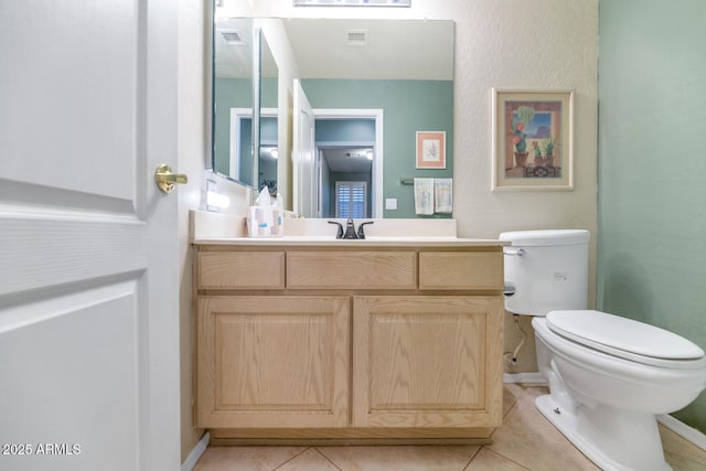 bathroom with toilet, tile patterned flooring, baseboards, and vanity