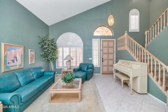 tiled living room with baseboards, high vaulted ceiling, and stairway