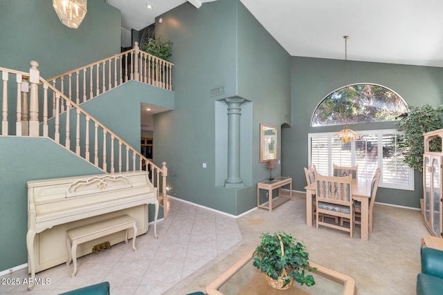 tiled living room with visible vents, a towering ceiling, baseboards, and stairway