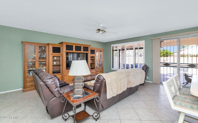 living area with ceiling fan, baseboards, and a wealth of natural light