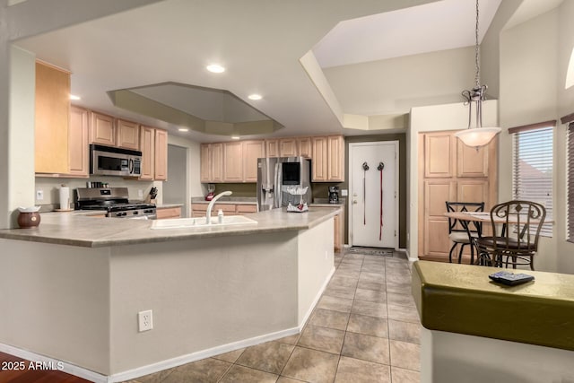 kitchen featuring a raised ceiling, appliances with stainless steel finishes, a sink, and light countertops
