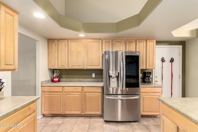 kitchen featuring light countertops, stainless steel fridge, and light brown cabinets