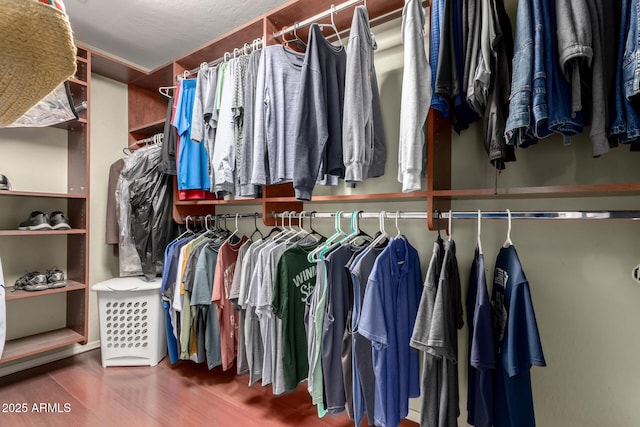 walk in closet with wood finished floors