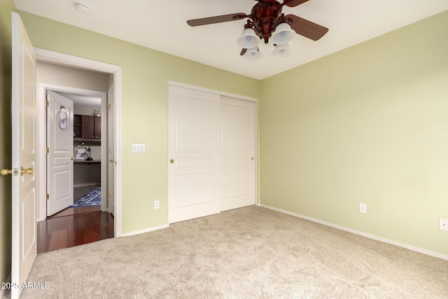 unfurnished bedroom featuring carpet, a closet, baseboards, and a ceiling fan