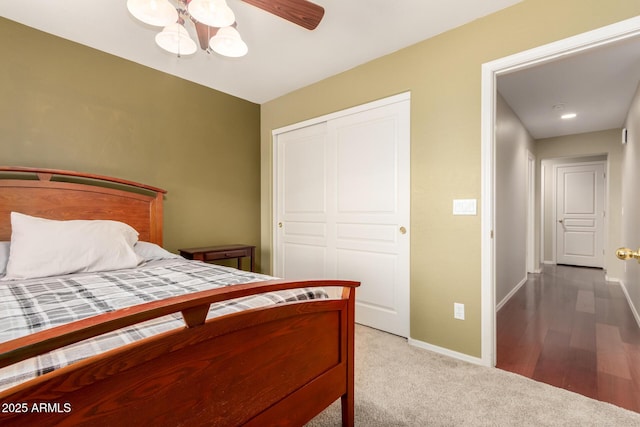 carpeted bedroom with a closet, baseboards, and ceiling fan