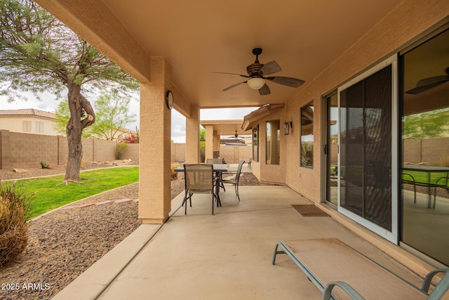view of patio featuring ceiling fan, fence, and outdoor dining area