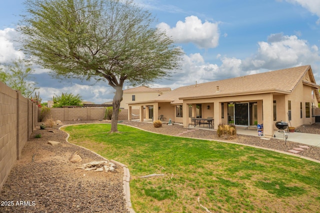 rear view of property featuring a patio, a fenced backyard, stucco siding, and a lawn