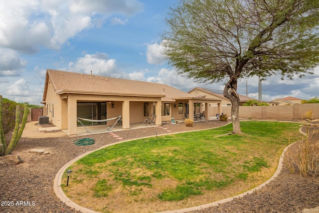 rear view of property with central air condition unit, a patio area, a lawn, a fenced backyard, and stucco siding