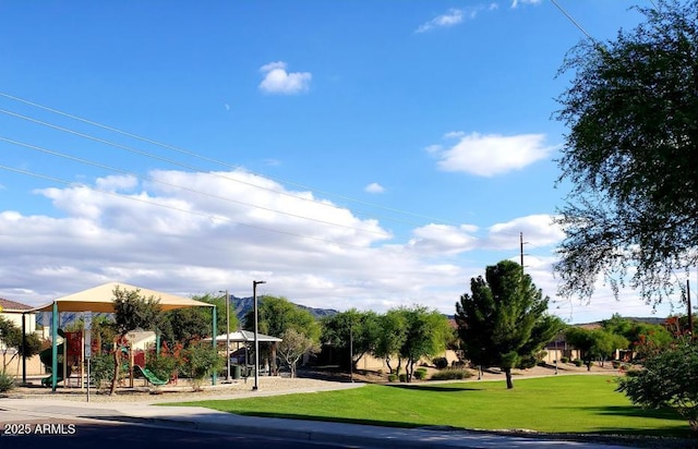 view of property's community featuring playground community and a lawn