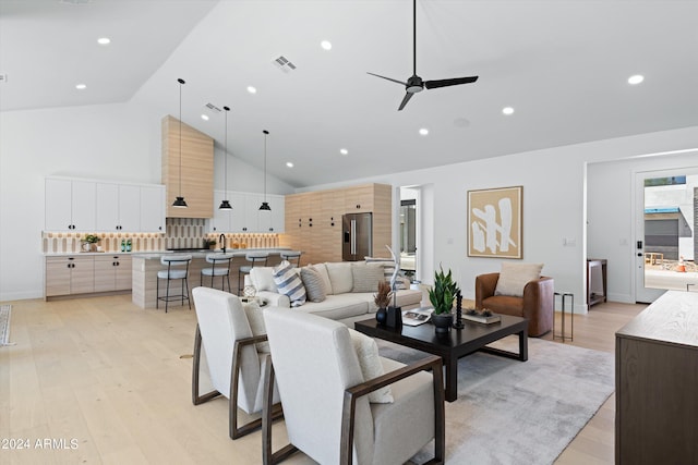 living room featuring ceiling fan, lofted ceiling, and light wood-type flooring