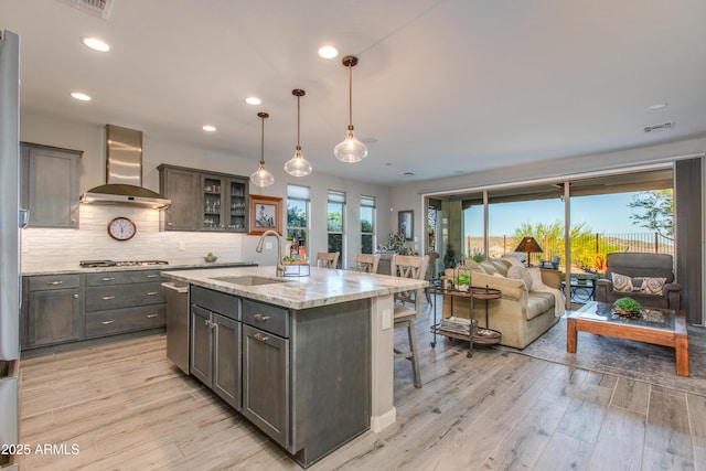 4577 Tenderfoot Way, Wickenburg, AZ 85390 - kitchen with visible vents, a sink, wall chimney exhaust hood, and light wood-style flooring