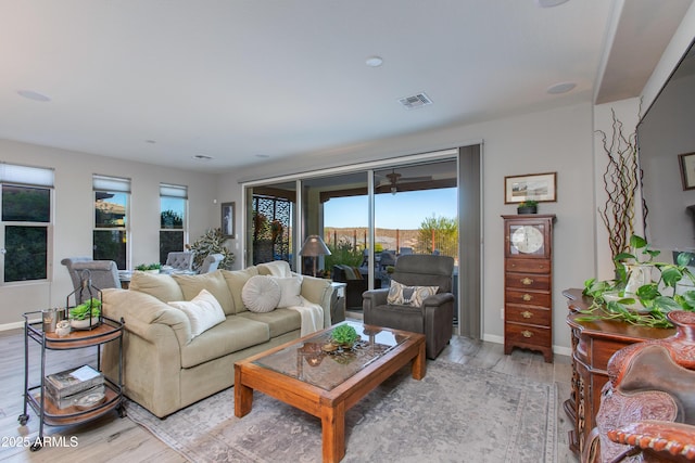 4577 Tenderfoot Way, Wickenburg, AZ 85390 - living room featuring visible vents, light wood-style floors, baseboards, and a healthy amount of sunlight