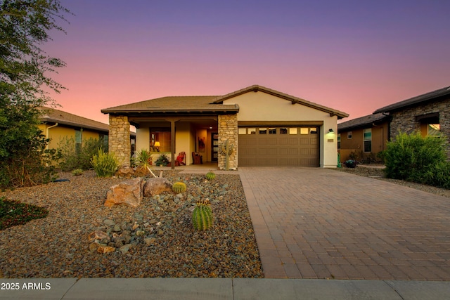 4577 Tenderfoot Way, Wickenburg, AZ 85390 - single story home featuring an attached garage, stone siding, stucco siding, decorative driveway, and covered porch