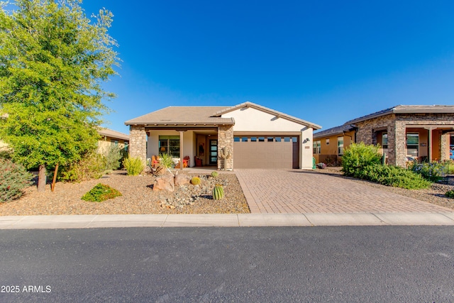 4577 Tenderfoot Way, Wickenburg, AZ 85390 - ranch-style house with an attached garage, driveway, stone siding, and stucco siding