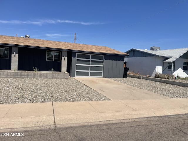 8520 E Mackenzie Dr, Scottsdale, AZ 85251 - view of front facade featuring board and batten siding, a garage, and concrete driveway