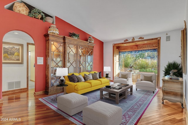 living room featuring lofted ceiling and hardwood / wood-style floors