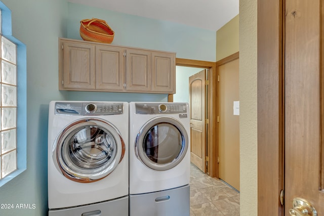 clothes washing area with cabinets and independent washer and dryer