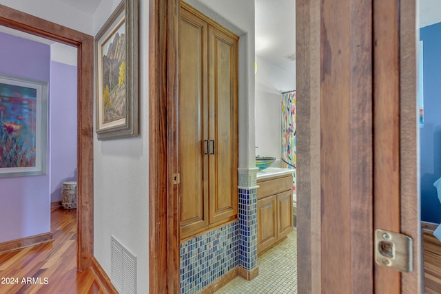 bathroom with a shower with shower curtain, wood-type flooring, and vanity