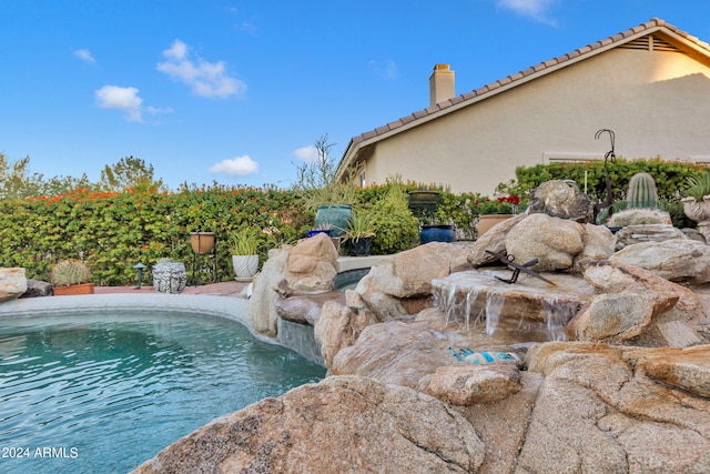 view of swimming pool featuring pool water feature