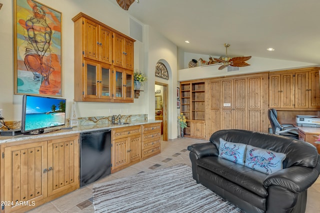 kitchen with ceiling fan, light stone counters, sink, high vaulted ceiling, and black dishwasher