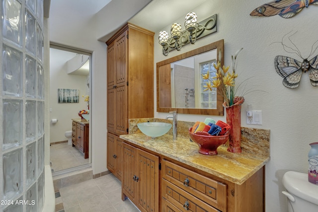 bathroom with walk in shower, vanity, toilet, and tile patterned floors