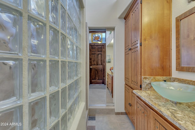 bathroom with vanity, a shower with shower door, and tile patterned flooring