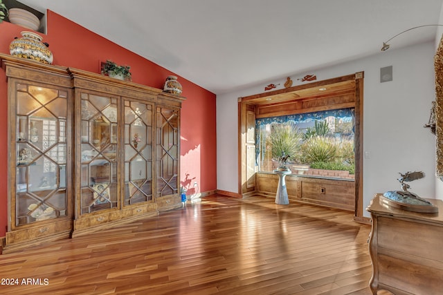 empty room with lofted ceiling and hardwood / wood-style floors