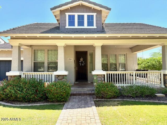 3765 N Denny Way, Buckeye, AZ 85396 - view of front of property with covered porch, a front lawn, and stucco siding