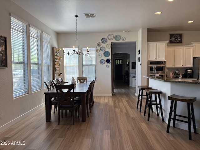 3765 N Denny Way, Buckeye, AZ 85396 - dining space with wood finished floors, a chandelier, recessed lighting, and arched walkways