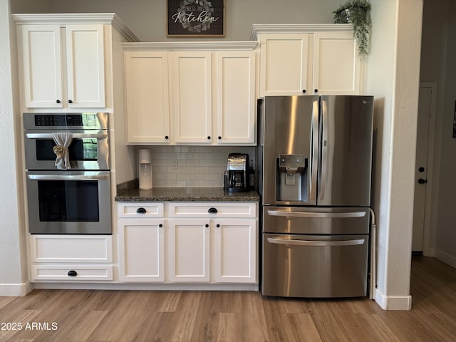 3765 N Denny Way, Buckeye, AZ 85396 - kitchen with stainless steel appliances, light wood-style flooring, white cabinets, and tasteful backsplash