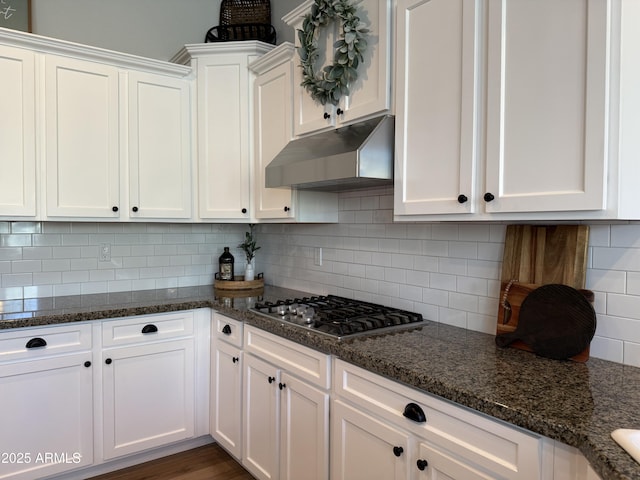3765 N Denny Way, Buckeye, AZ 85396 - kitchen featuring under cabinet range hood, stainless steel gas cooktop, white cabinets, decorative backsplash, and dark stone counters