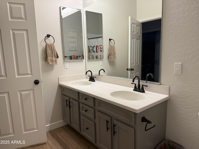 3765 N Denny Way, Buckeye, AZ 85396 - bathroom with double vanity, wood finished floors, and a textured wall