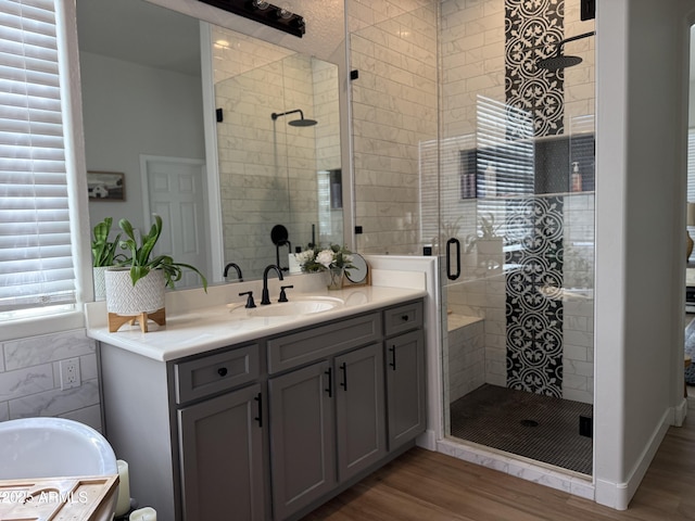 3765 N Denny Way, Buckeye, AZ 85396 - bathroom featuring vanity, wood finished floors, a stall shower, tile walls, and a bath