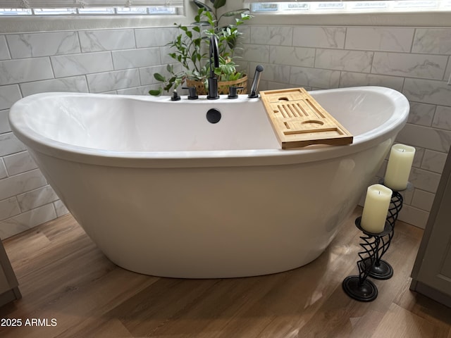 3765 N Denny Way, Buckeye, AZ 85396 - bathroom with tile walls, wood finished floors, and a freestanding bath