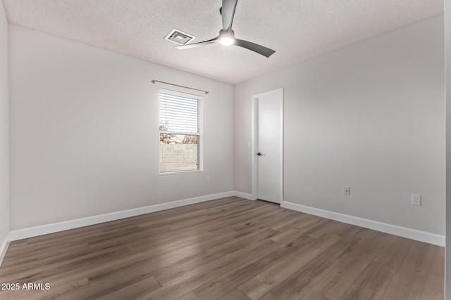 unfurnished room with ceiling fan, dark hardwood / wood-style flooring, and a textured ceiling