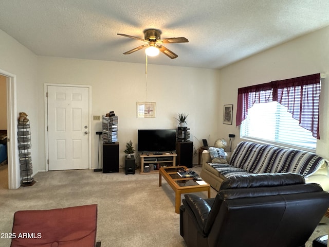 living area featuring carpet flooring, a textured ceiling, and a ceiling fan