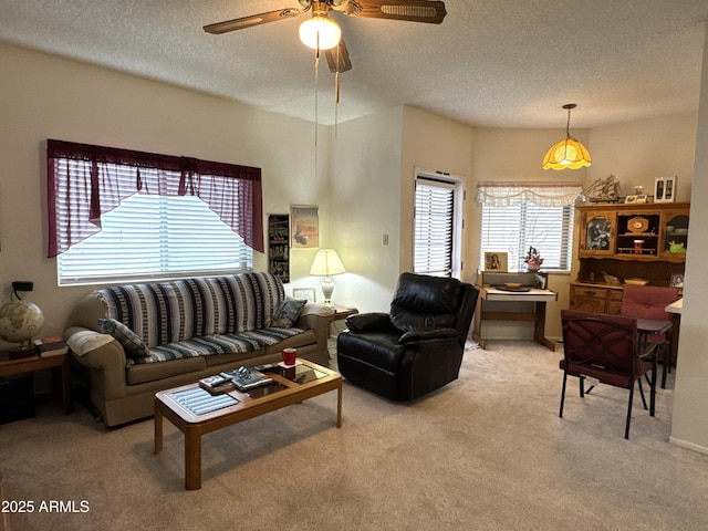 carpeted living room featuring a textured ceiling and ceiling fan