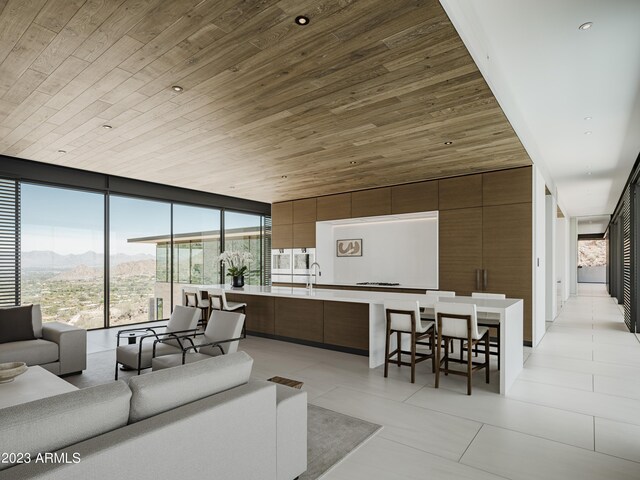 tiled living room featuring sink, a mountain view, wooden ceiling, and expansive windows