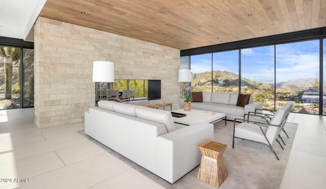 living room featuring a wall of windows, a fireplace, tile patterned floors, recessed lighting, and wood ceiling