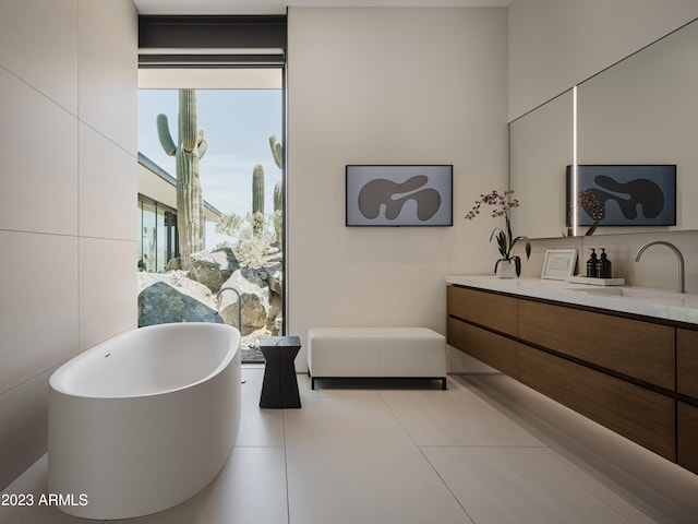 bathroom featuring vanity, a bathtub, tile walls, and tile patterned floors