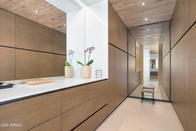 hallway featuring tile walls and light tile patterned floors