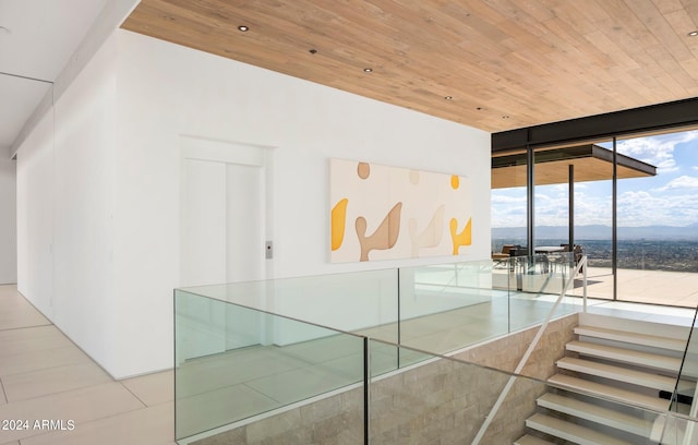 hall featuring wood ceiling, expansive windows, and a mountain view