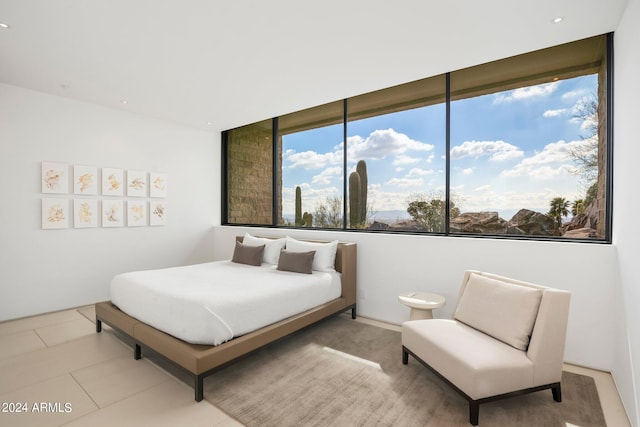 tiled bedroom featuring a wall of windows