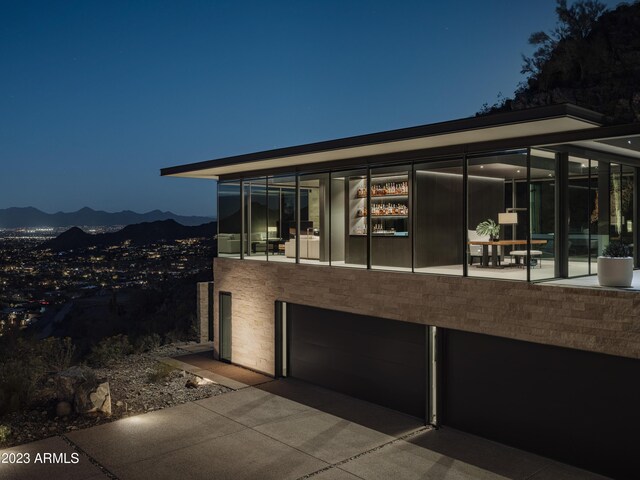 property exterior at twilight featuring a mountain view and a garage