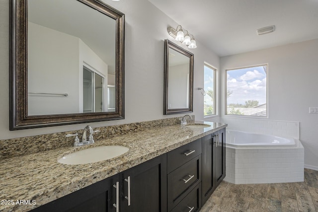 8518 S 8th Ln, Phoenix, AZ 85041 - bathroom with wood finished floors, double vanity, and a bath